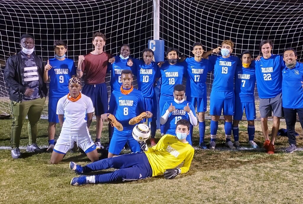 Catalina High School soccer players posing in front of Goal post. They are wearing blue uniforms with white lettering. Goalie is in yellow.