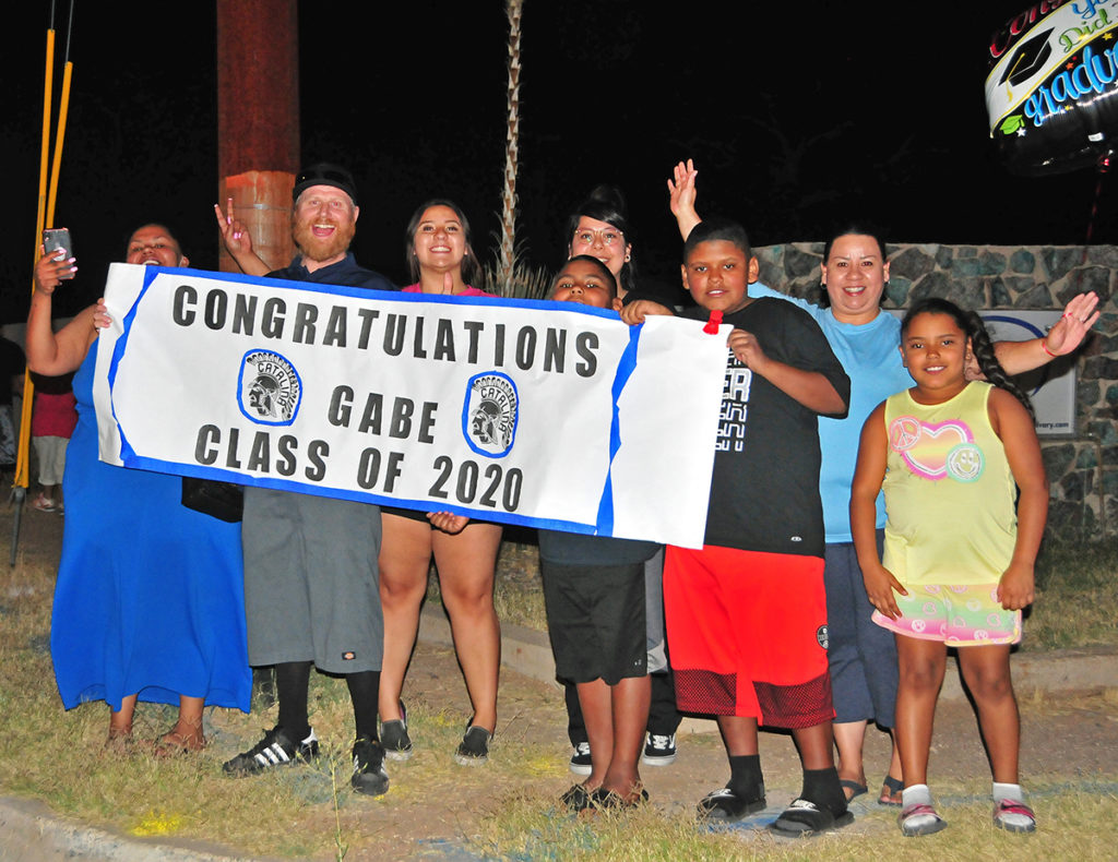 Kid's family holding banner "Congratulations Gabe Class of 2020"